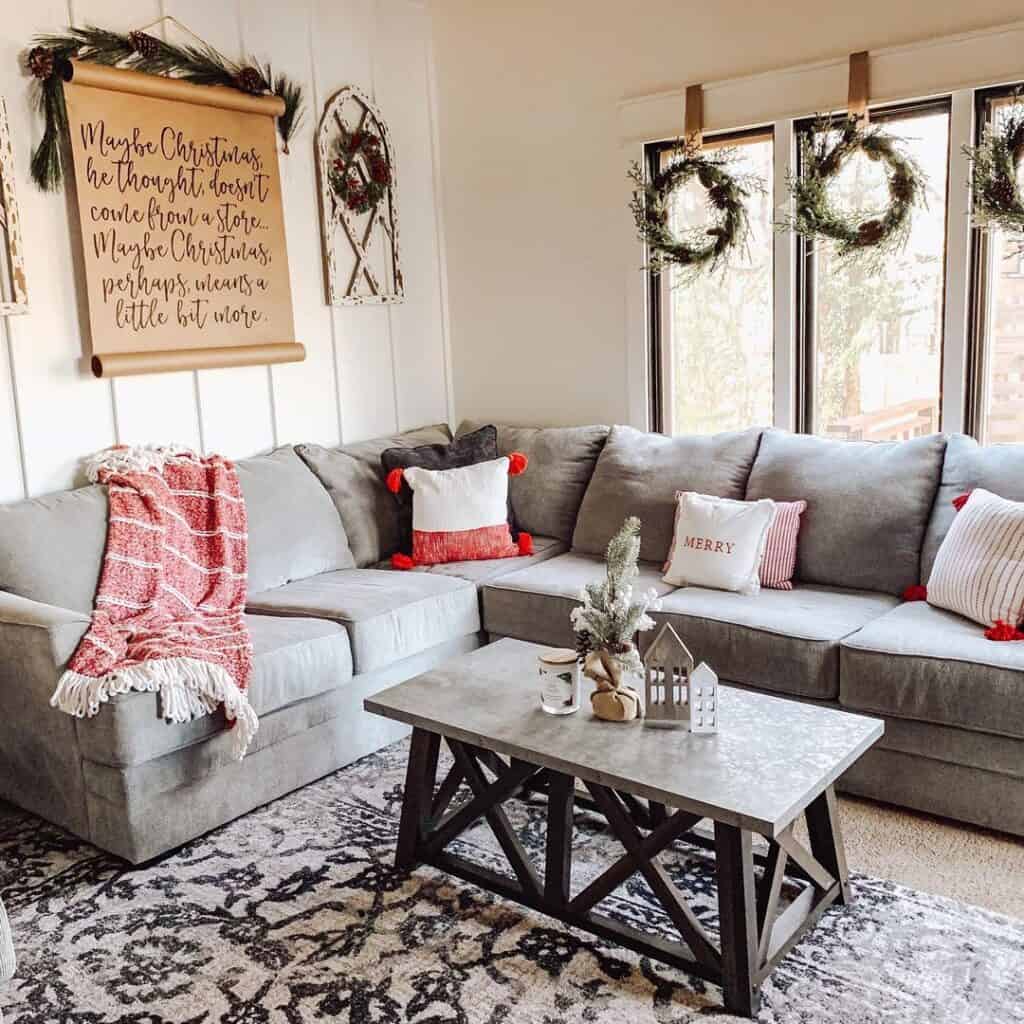 Farmhouse living room featuring grey sectional couch and coffee table next to board and batten wall