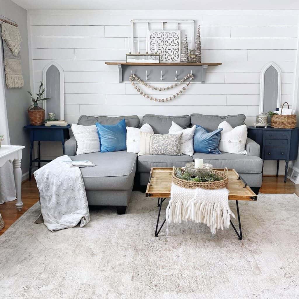 Farmhouse living room with white shiplap accent wall and grey sectional