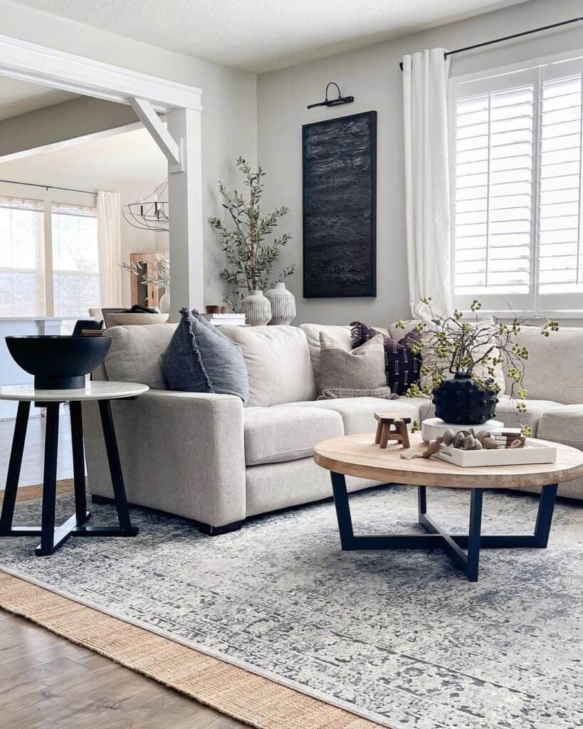 black and wood round coffee table with gray sectional sofa