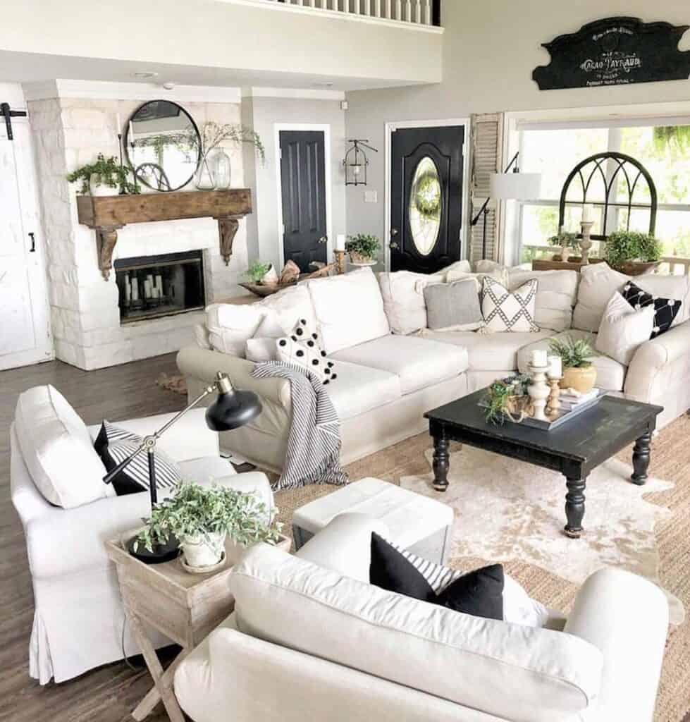 cream sectional couch and dark rectangular coffee table next to two slipcovered armchairs