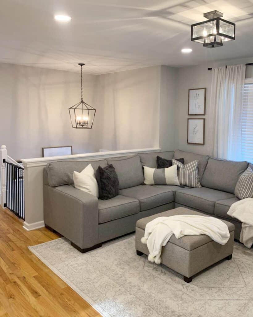 gray sectional couch next to ottoman used as coffee table in a living room painted in Agreeable Gray by Sherwin-William