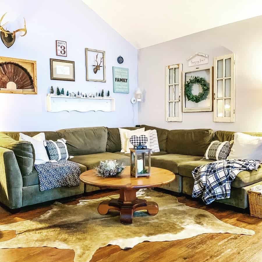 round wood pedestal coffee table on a cowhide rug next to gray sectional