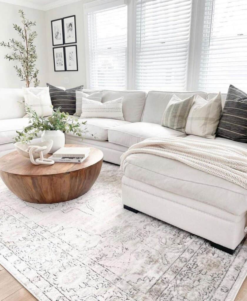 wooden round coffee table next to a beige sectional couch
