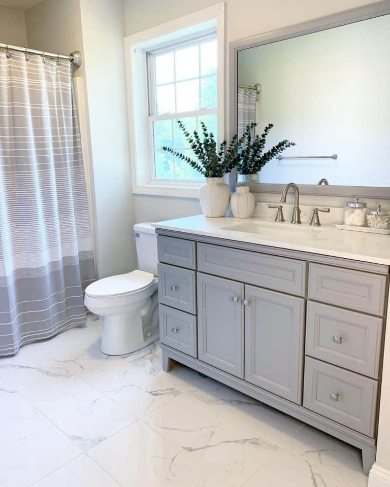 White Toilet Next to Gray Bathroom Vanity