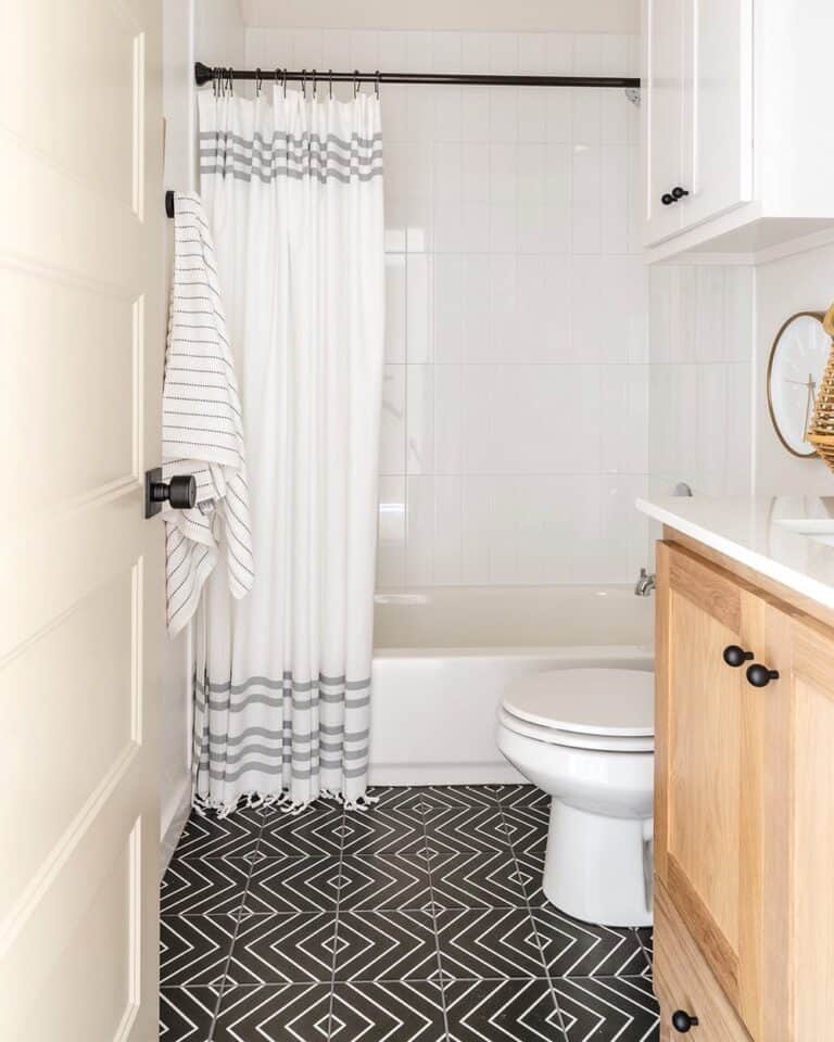 Black Tile Bathroom With White Shower Tiles And White Curtain