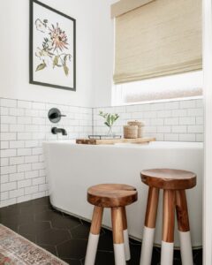 Black Tile Bathroom With White Oval Bathtub And Subway Tile Surround