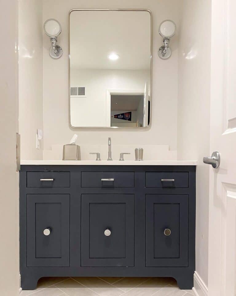 Dark Grey Bathroom Cabinet Sits In a White Nook