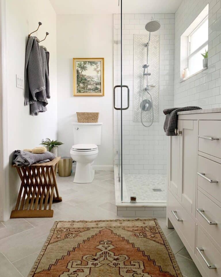 Glass Shower Doors Next to Grey Bathroom Cabinet