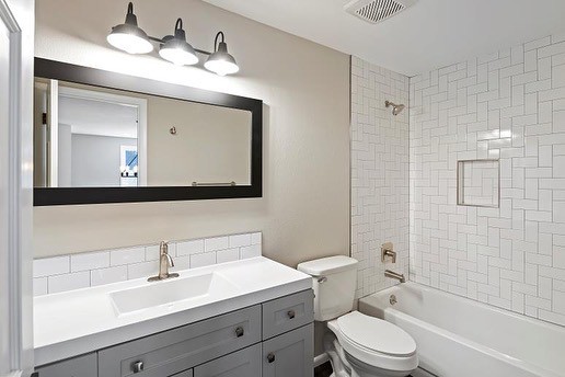 Grey Bathroom Cabinets Offset By Straight Herringbone Tile