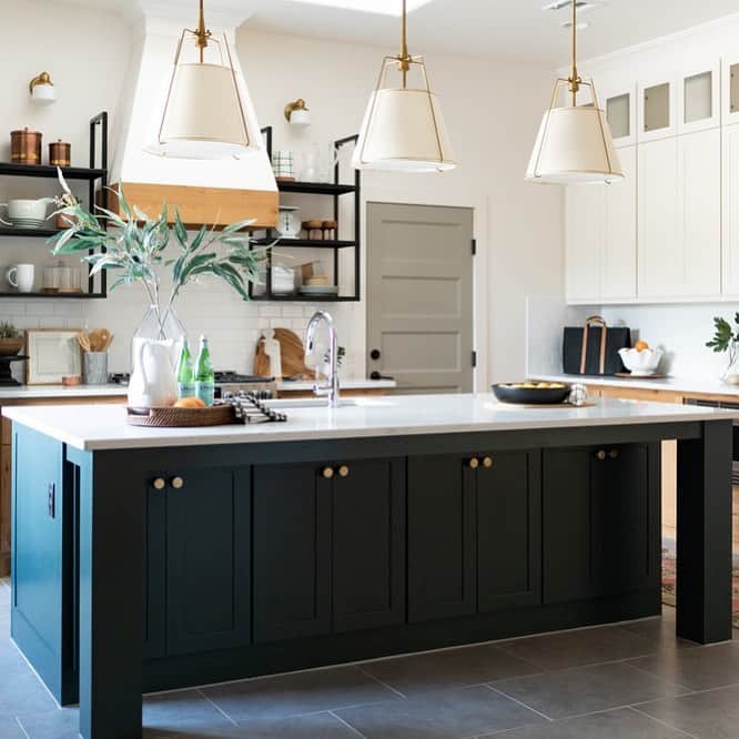 White and Gold Pendant Lamps Above Dark Grey Island