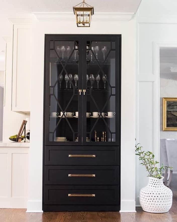 Black China Cabinet Next to White Kitchen Cabinets