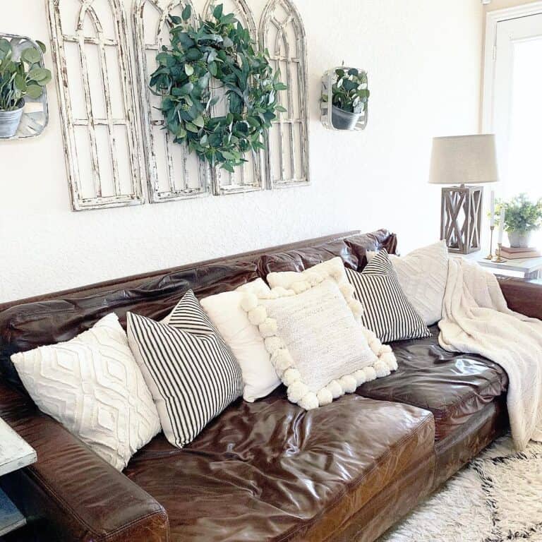 Dark Brown Leather Couch with White and Striped Throw Pillows