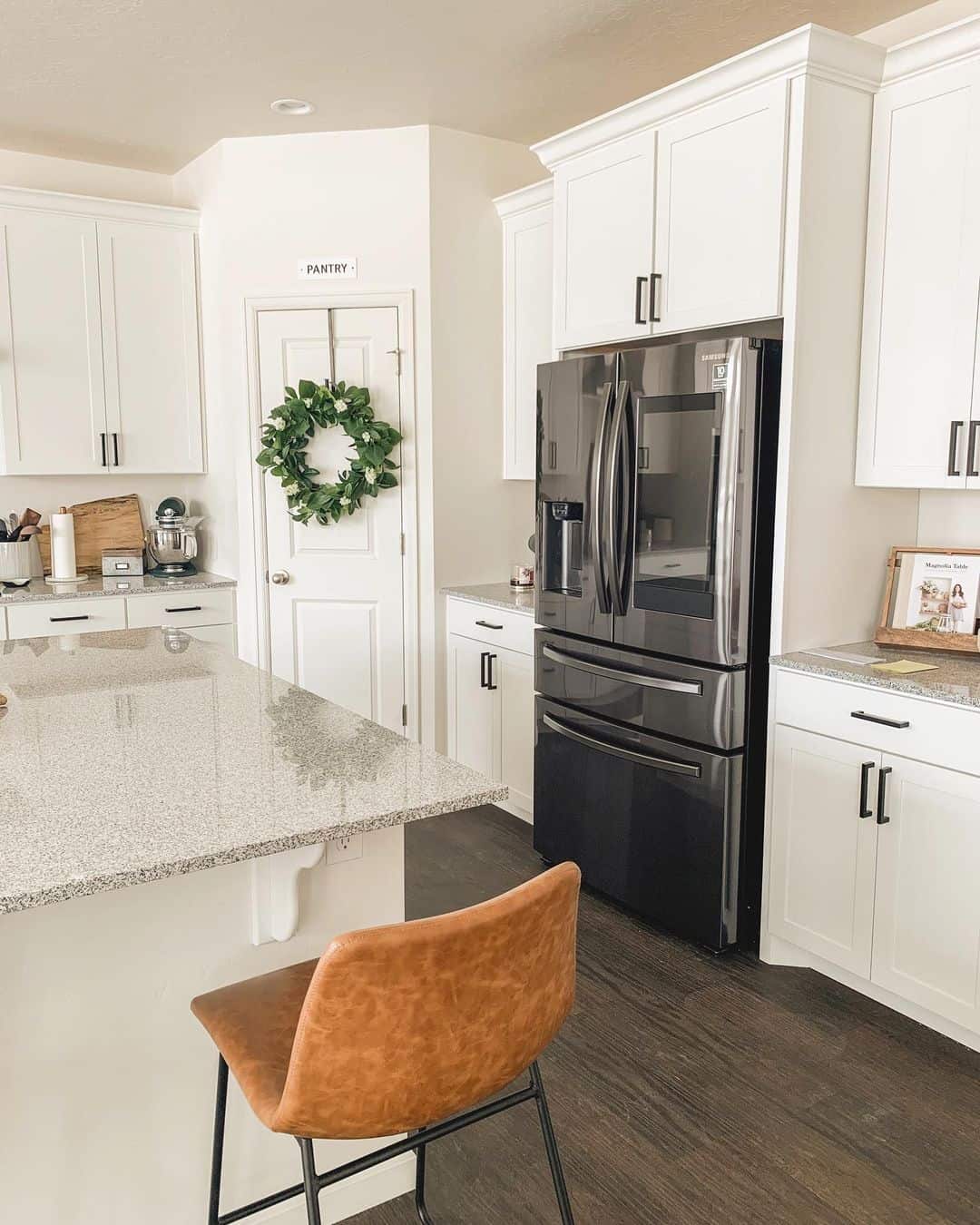White kitchen with store black fridge