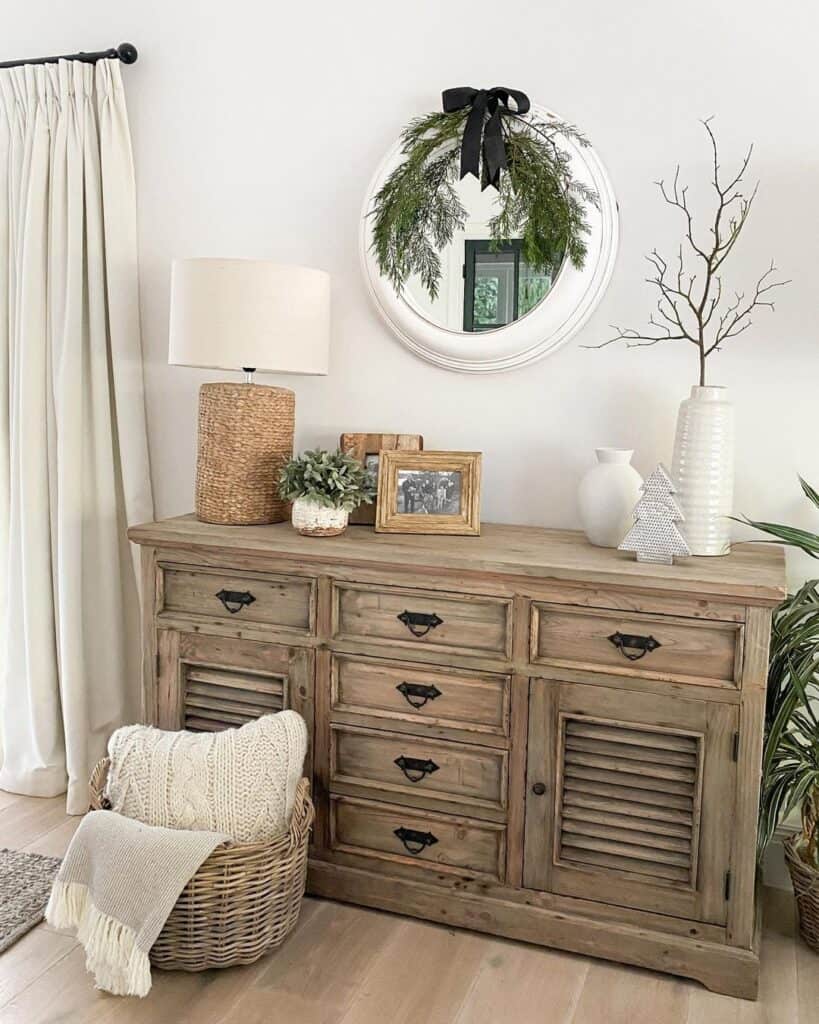 Round White Mirror Over a Wood Sideboard