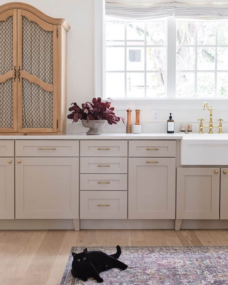Taupe and White Kitchen With Brass Knobs