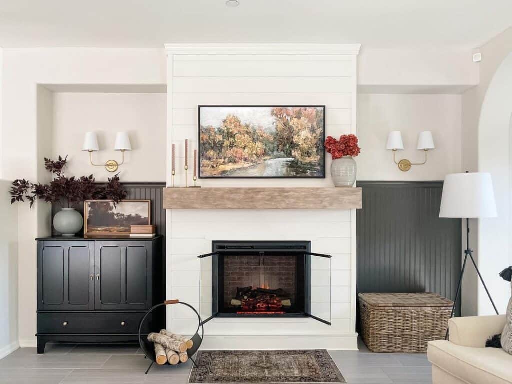 Two Gold Sconces Above Black Wainscoting