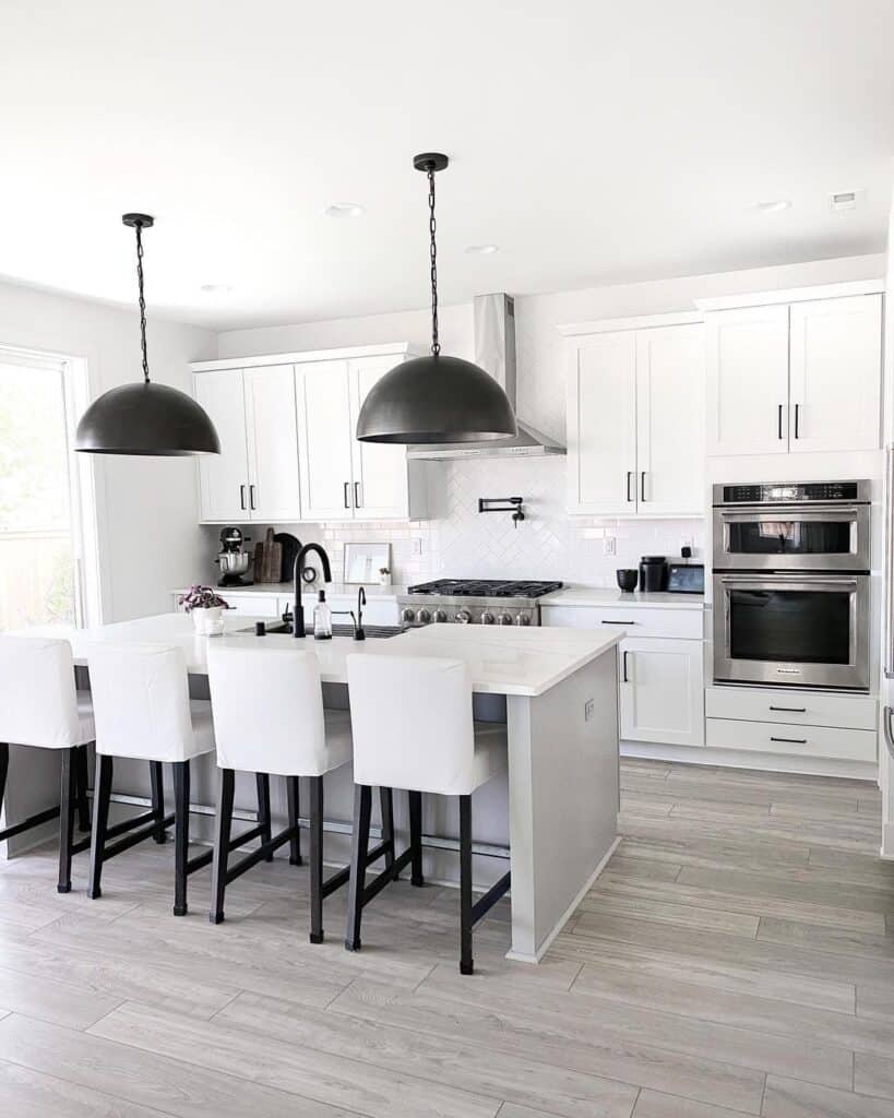 Two Large Black Pendant Lamps and White Cabinets