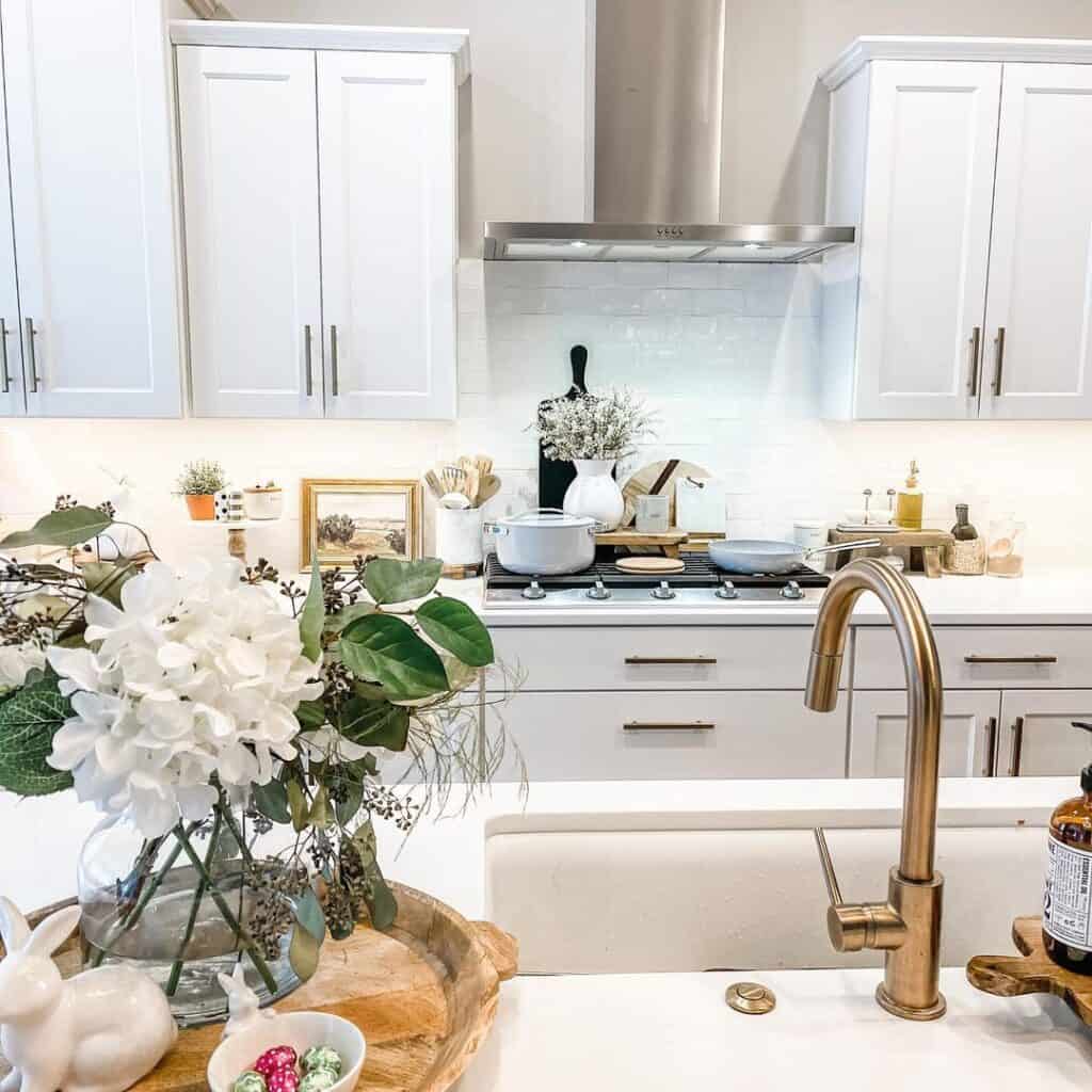 White Flowers Near Brass Kitchen Faucet