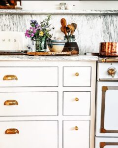 White Kitchen with Gray Countertops and Brass Hardware