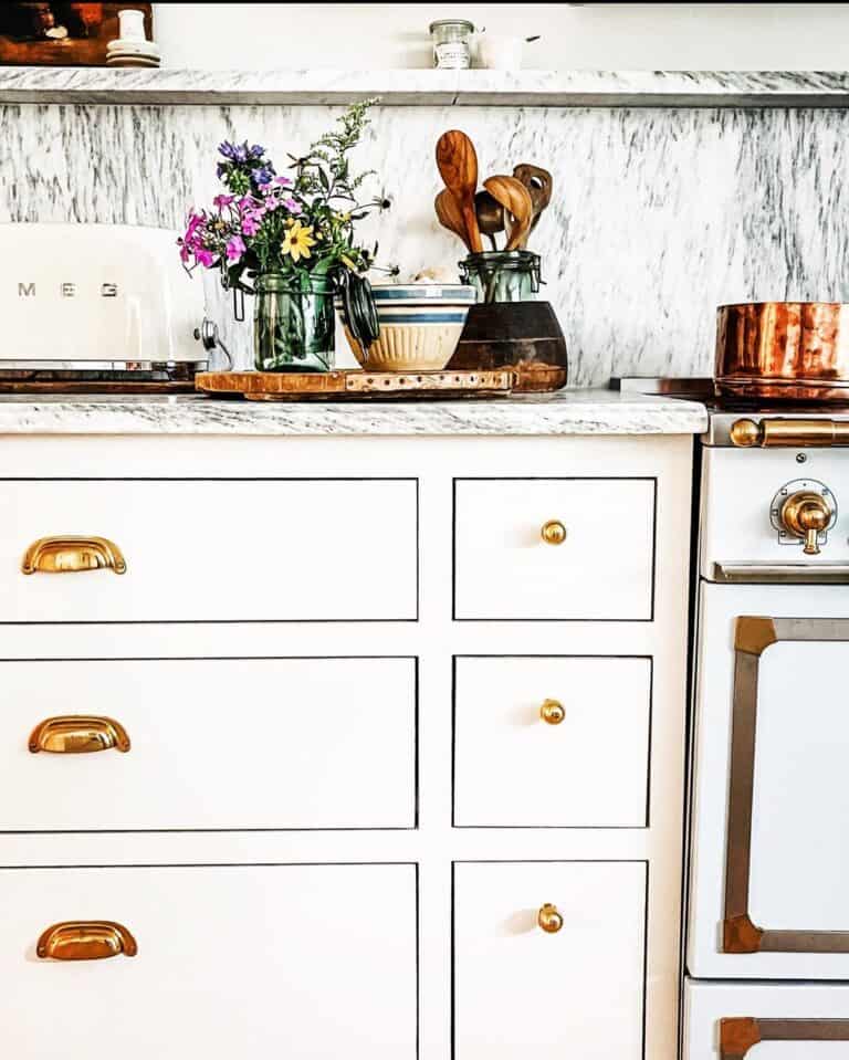 White Kitchen with Gray Countertops and Brass Hardware