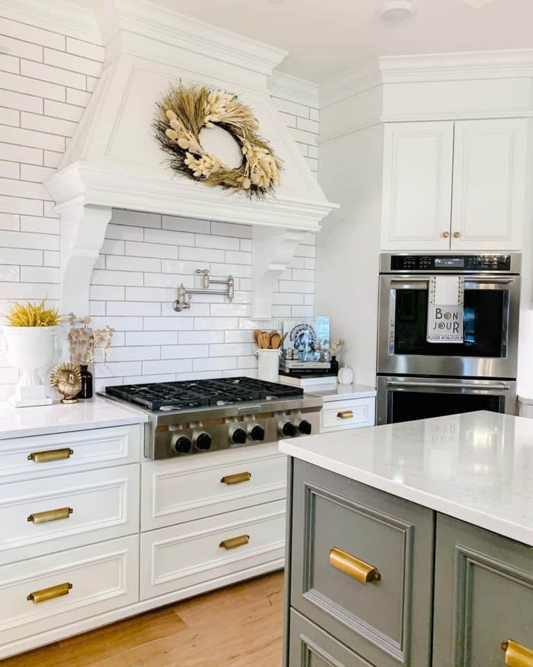 White Kitchen with Gray Island and Brass Hardware