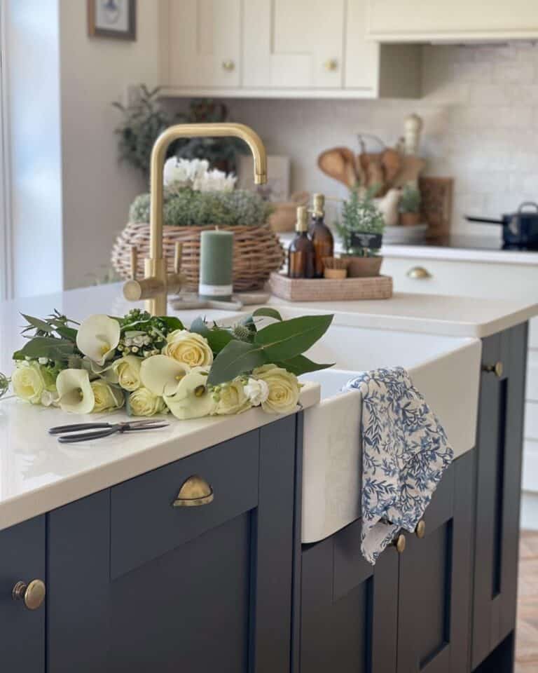 White Roses Laid Near a Brass Kitchen Faucet
