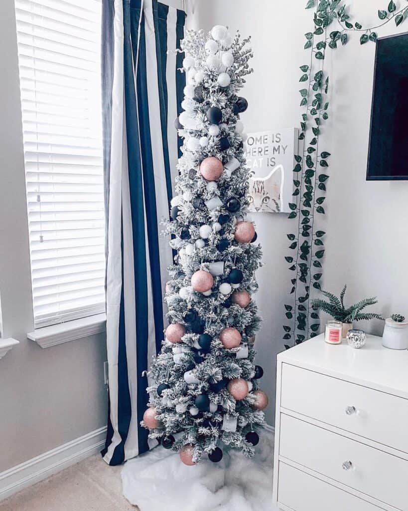 Bedroom with Thin Pencil Tree Hung with Pink and Black Ornaments