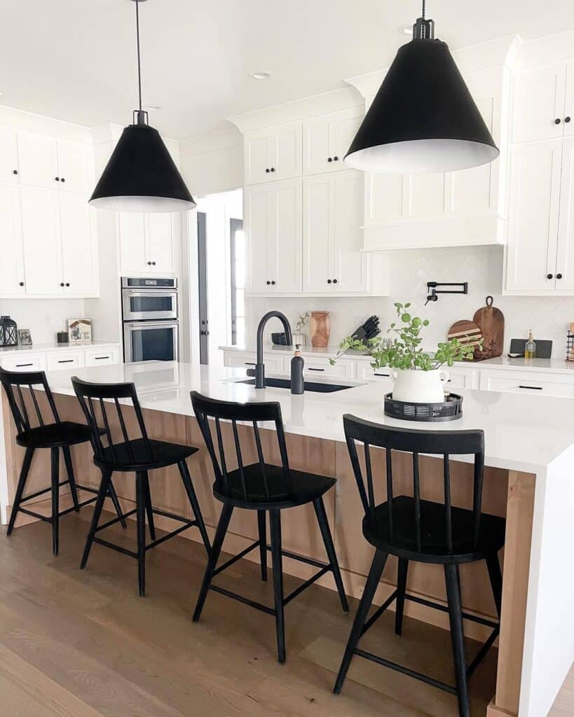 Black Pendant Lamps Over Matte Black Bar Stools