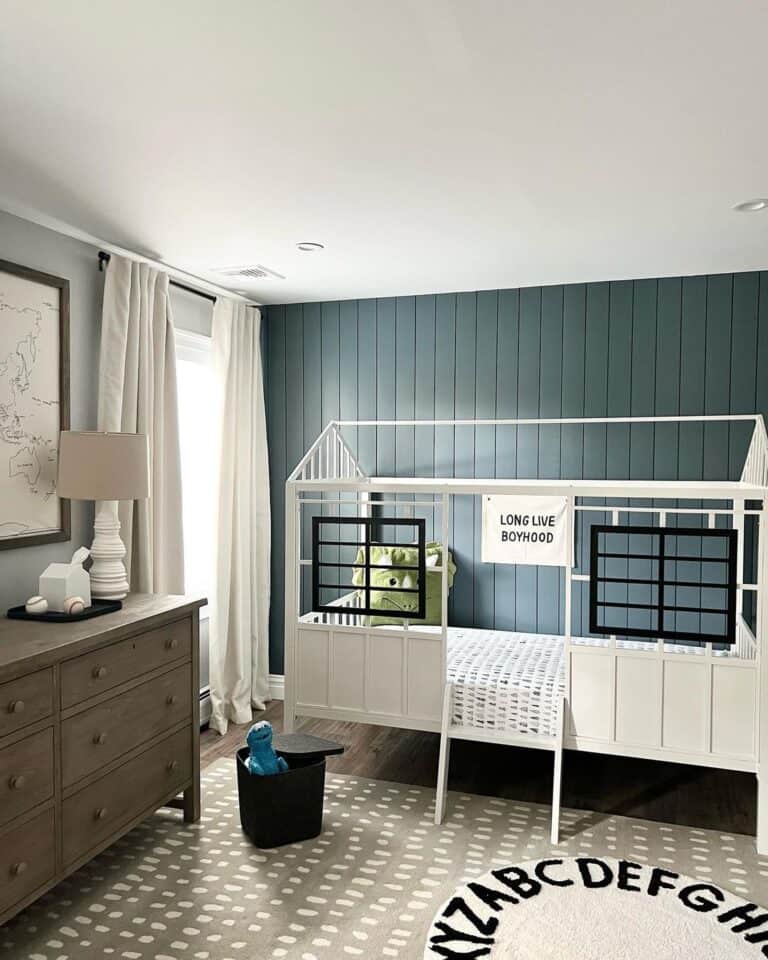 Blue-Gray Nursery Feature Wall with Dark Wood Dresser