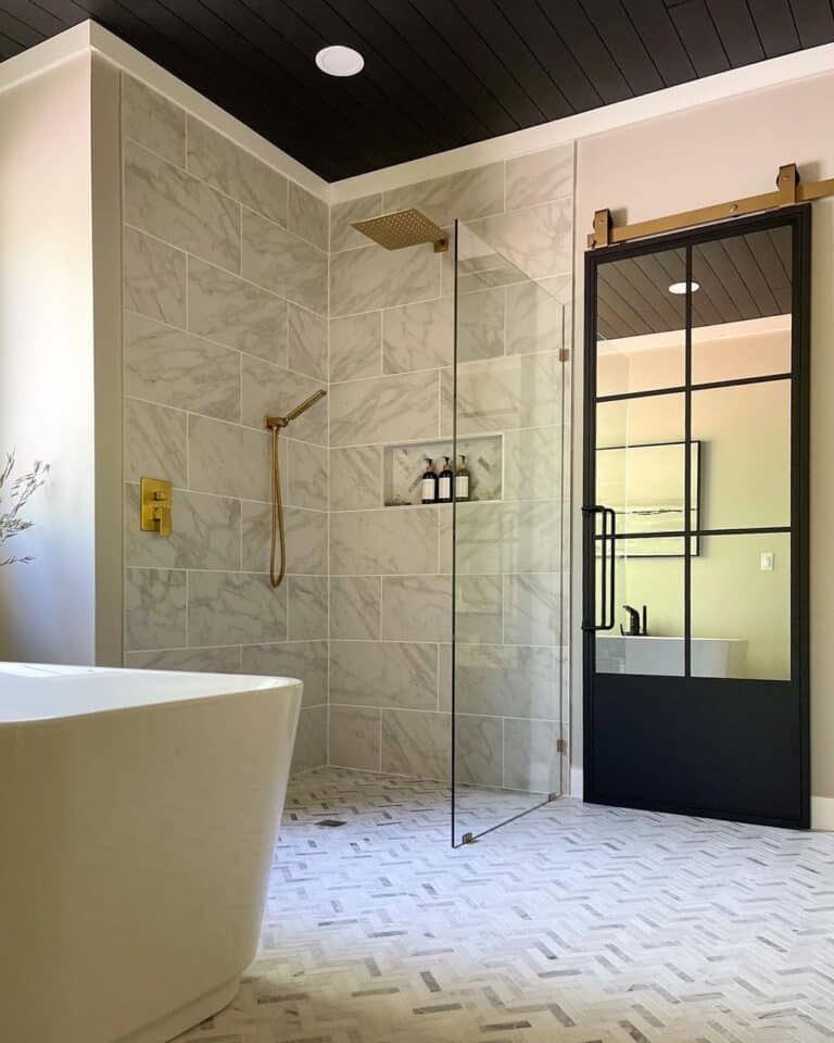 Brass Rain Shower Head Above a Herringbone Floor