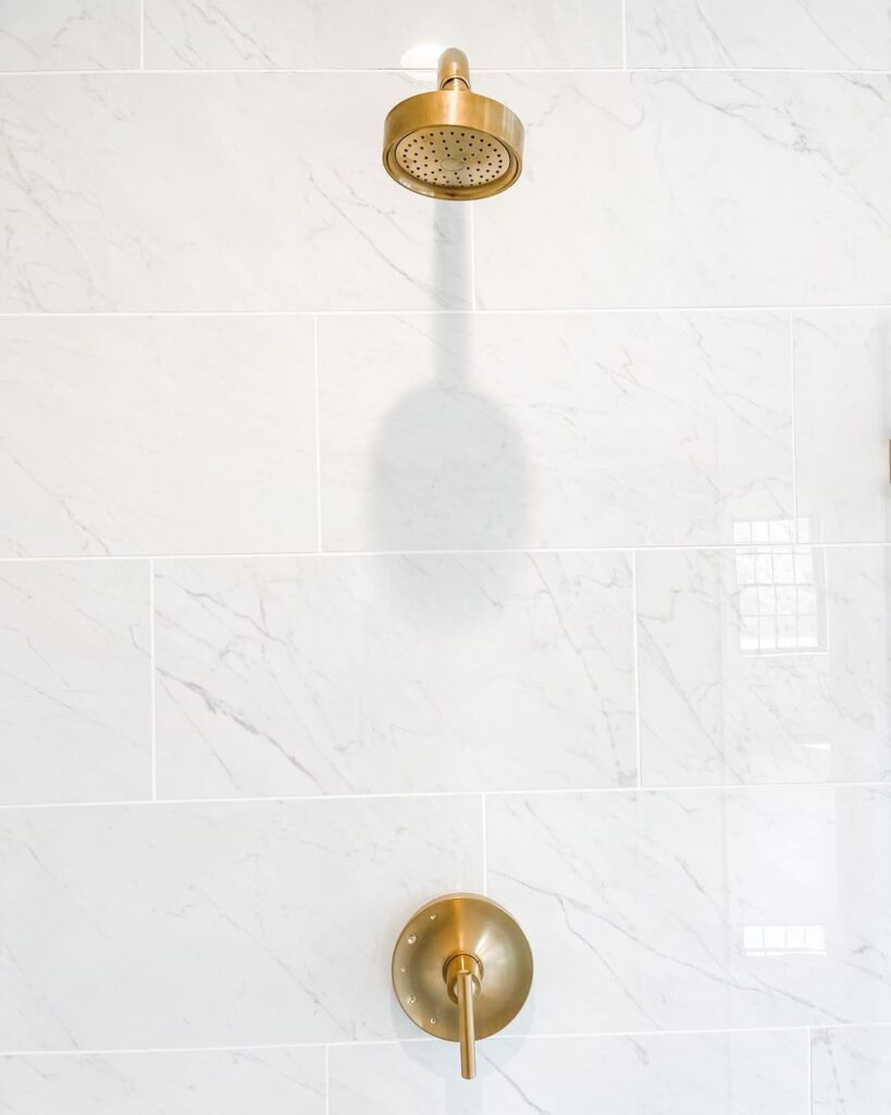 Brushed Brass Shower Head on Marble Shower Wall