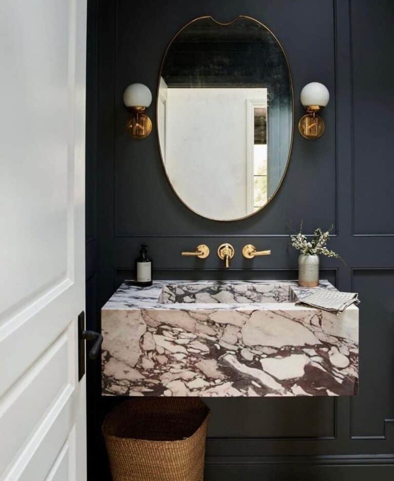 Floating Marble Sink Beneath Brass Sconces