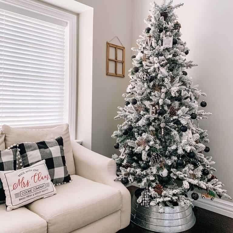 Flocked Christmas Tree with Black and White Decorations and Matching Throw Pillows
