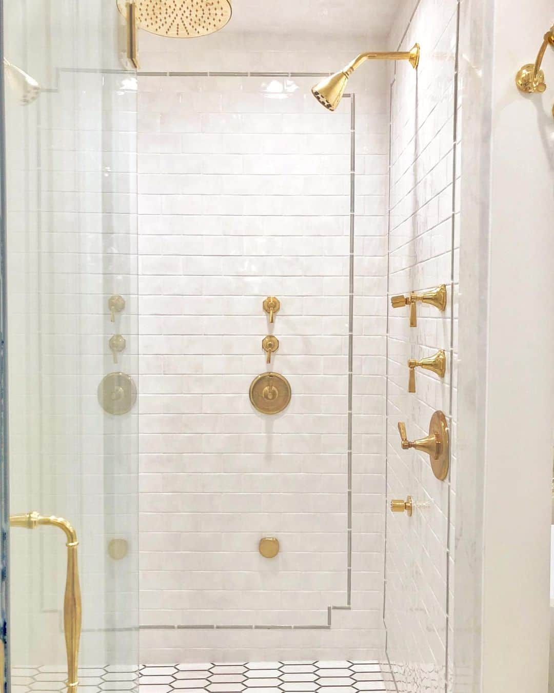 Polished Brass Shower Head on a White Tile Wall Soul & Lane