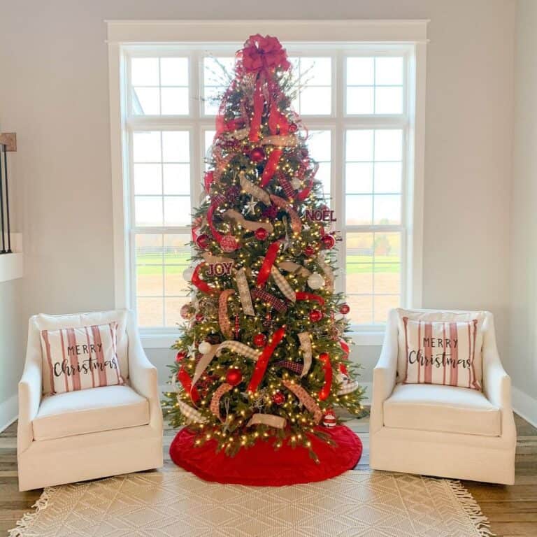 Red Decorated Tree Between White Armchairs