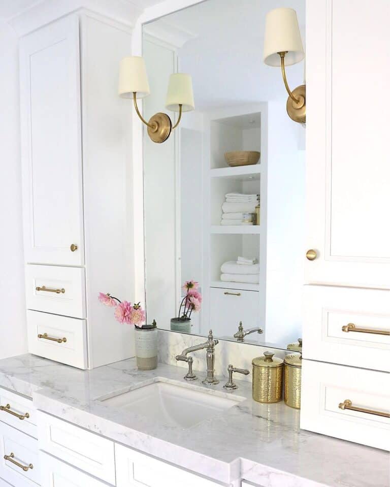 White Cabinets Surrounding Vanity Mirror and Sconces