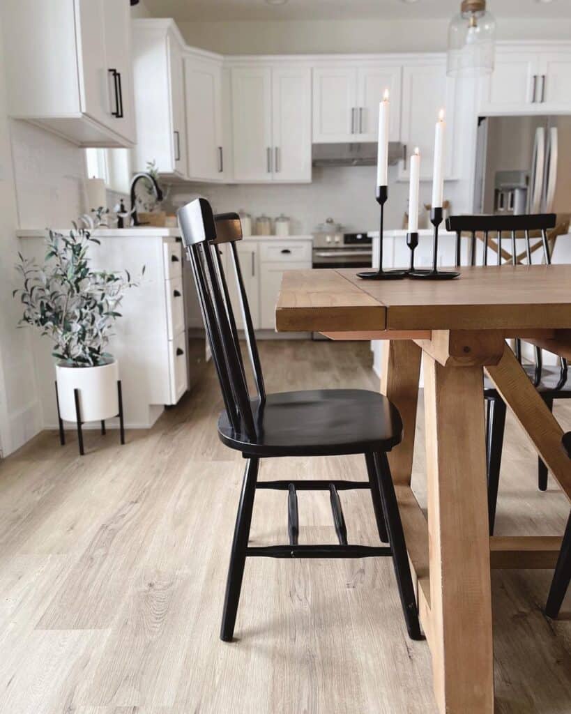 White Kitchen with Light Wood Floors and Black Chairs