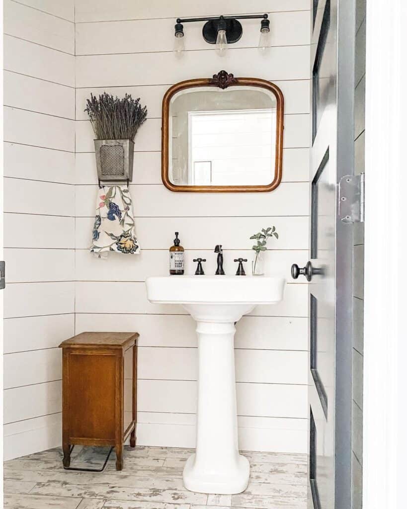 White Pedestal Sink in Farmhouse Bathroom