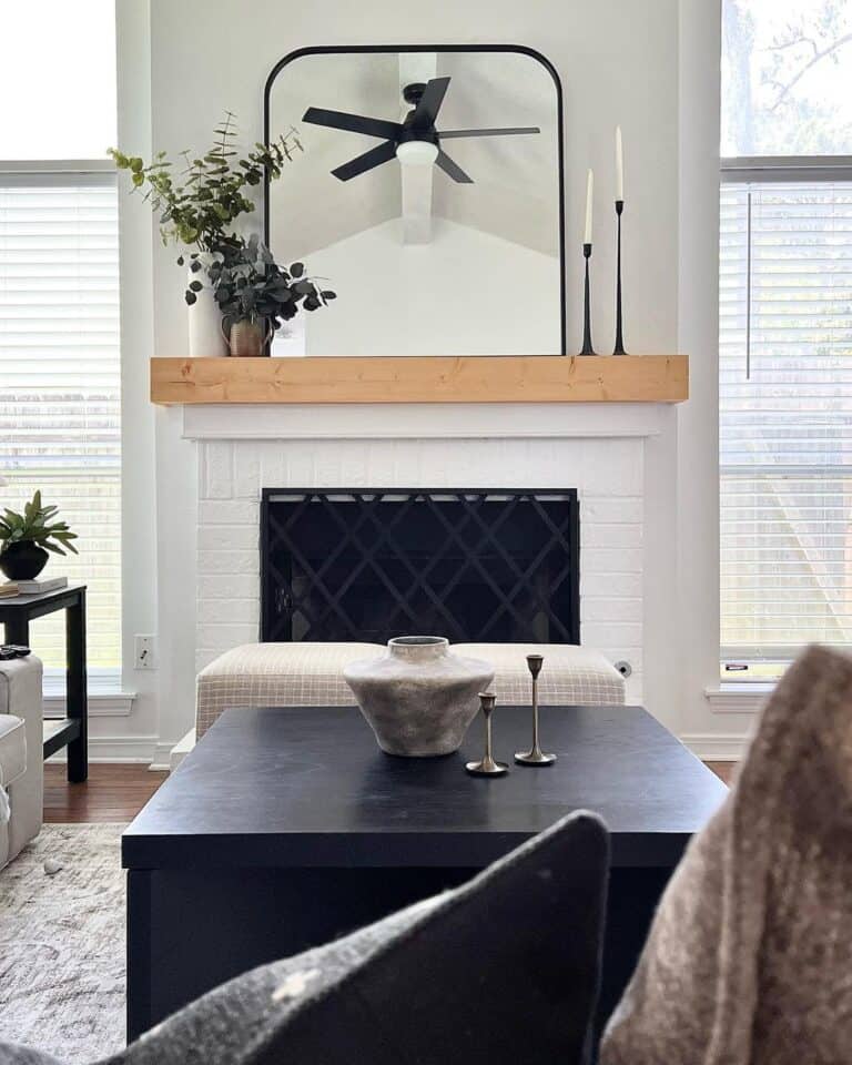 A Black Fire Screen With a White Brick Fireplace
