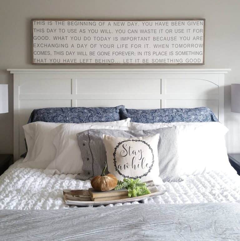 Bed with White Headboard and Wooden Sign