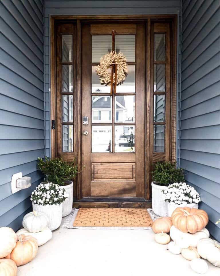 Dark Blue Home Exterior with Wood Door and Pumpkins