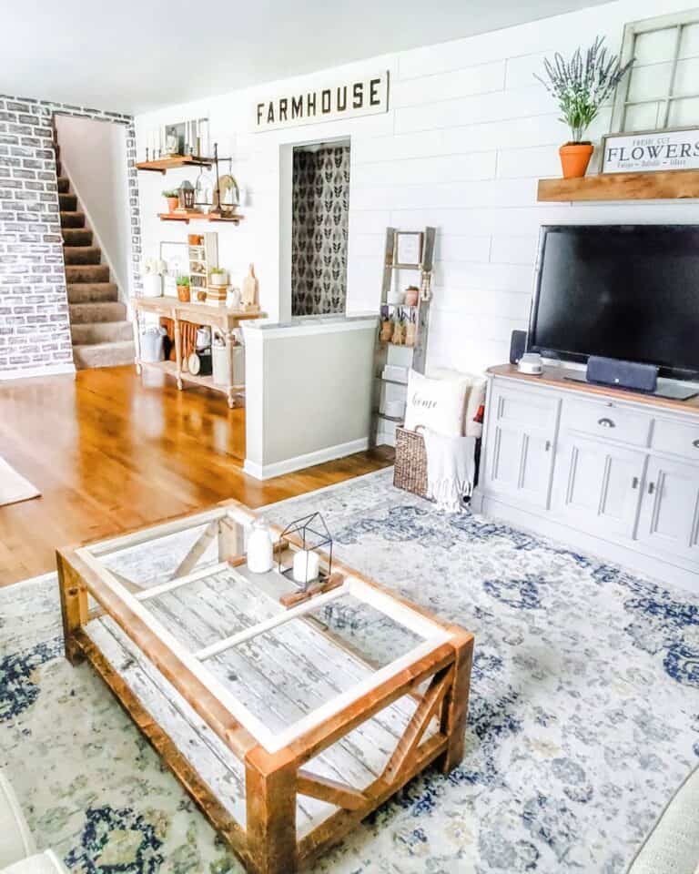 Glass Coffee Table with a Wood Base and Purple Flowers in an Orange Vase