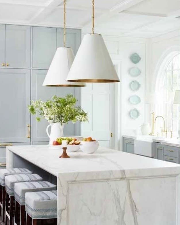 Large White and Gold Pendant Lamps Over a Marbled Kitchen Isand