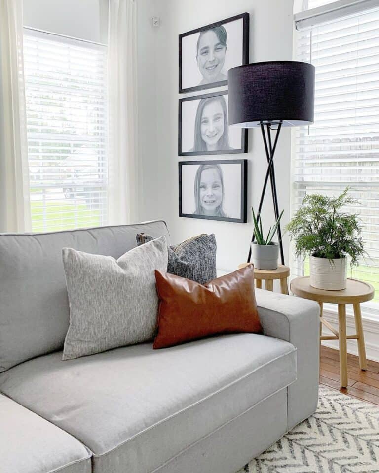 Portraits in Black Frames Behind a Black Floor Lamp