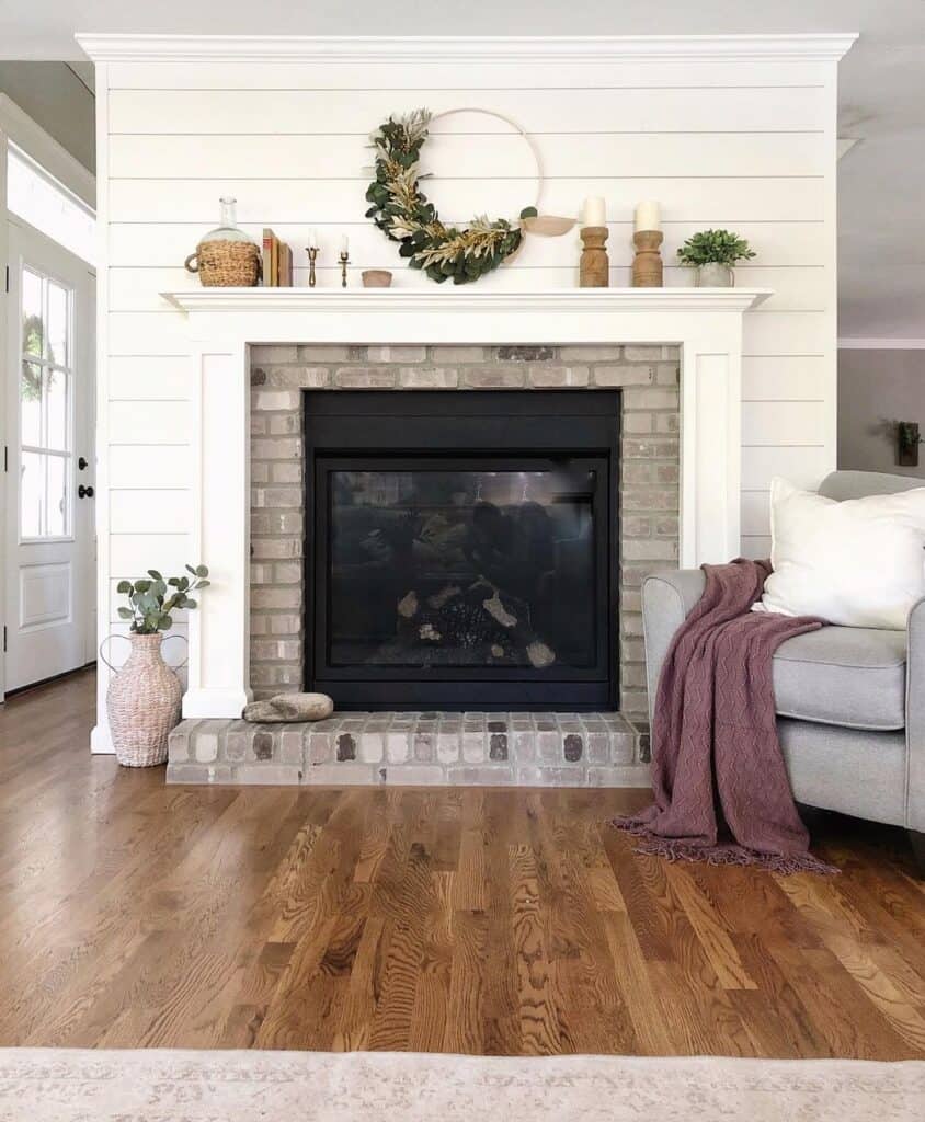 White and Exposed-Brick Fireplace on Shiplap Wall