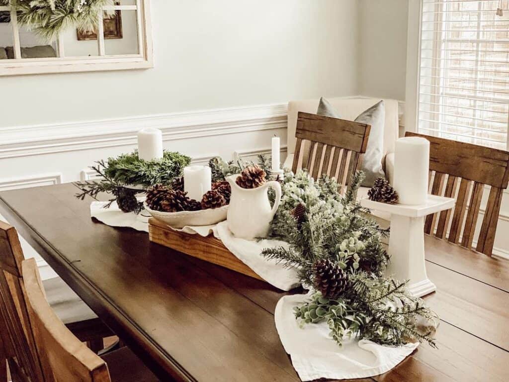 Wood Dining Table with White Draped Cloth and Pine Bough Decorations