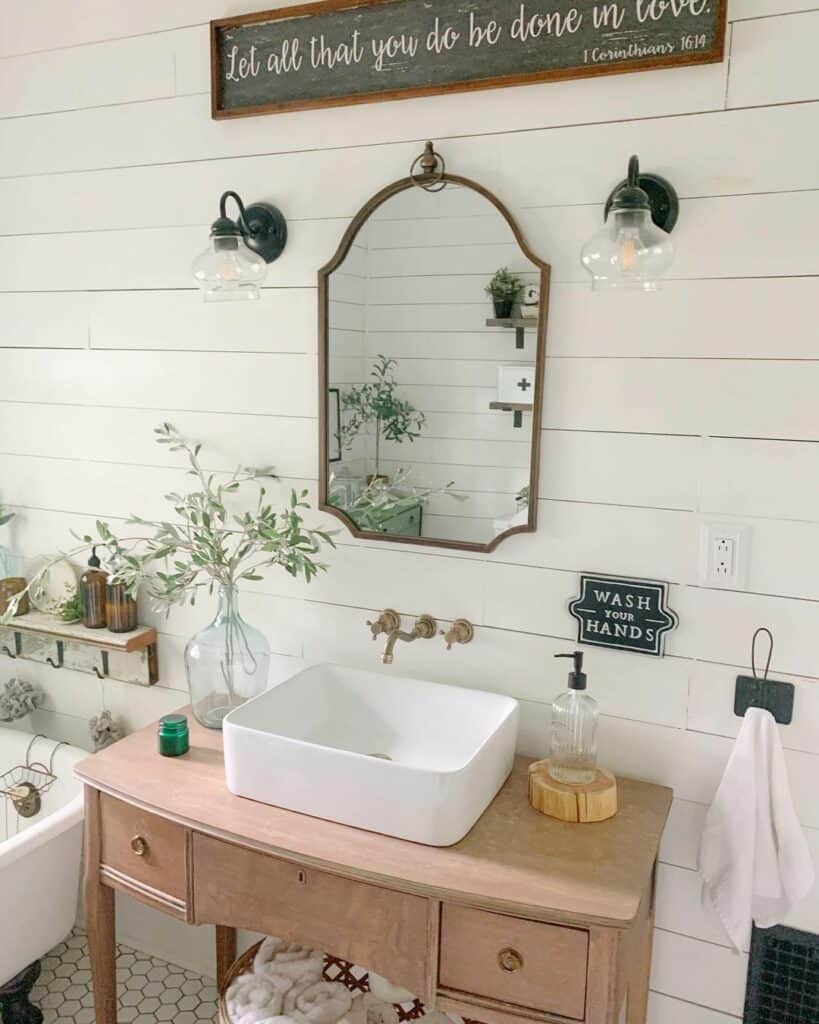 A Black Sign on a White Shiplap Bathroom Wall