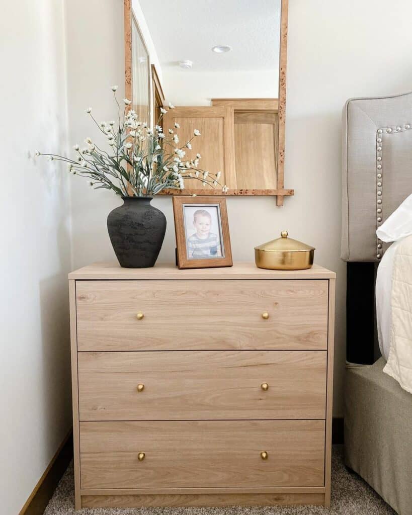 Framed Mirror Above Nightstand with Brass Knobs