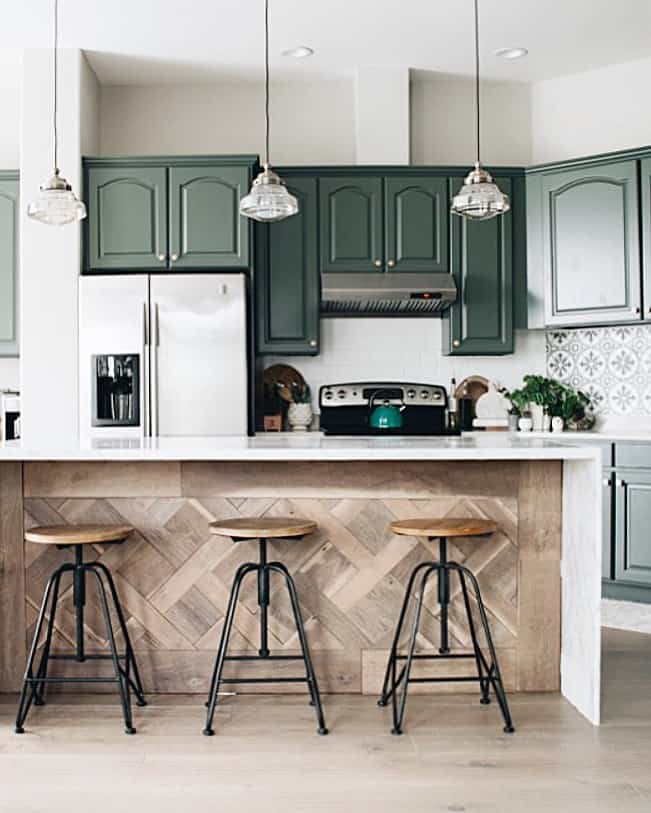 Green Raised Paneled Kitchen Cabinets Above a Green Teapot