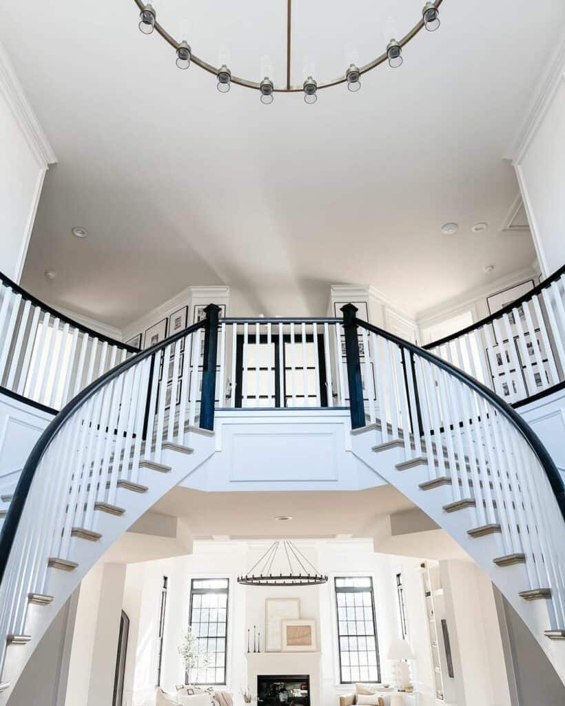 Two Dramatic Black and White Curved Staircases in a Foyer